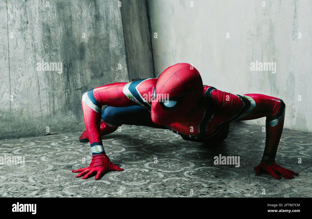 Schauspieler kleiden sich als Spiderman, der gegen eine alte Wand posiert  Das Studio Stockfotografie - Alamy