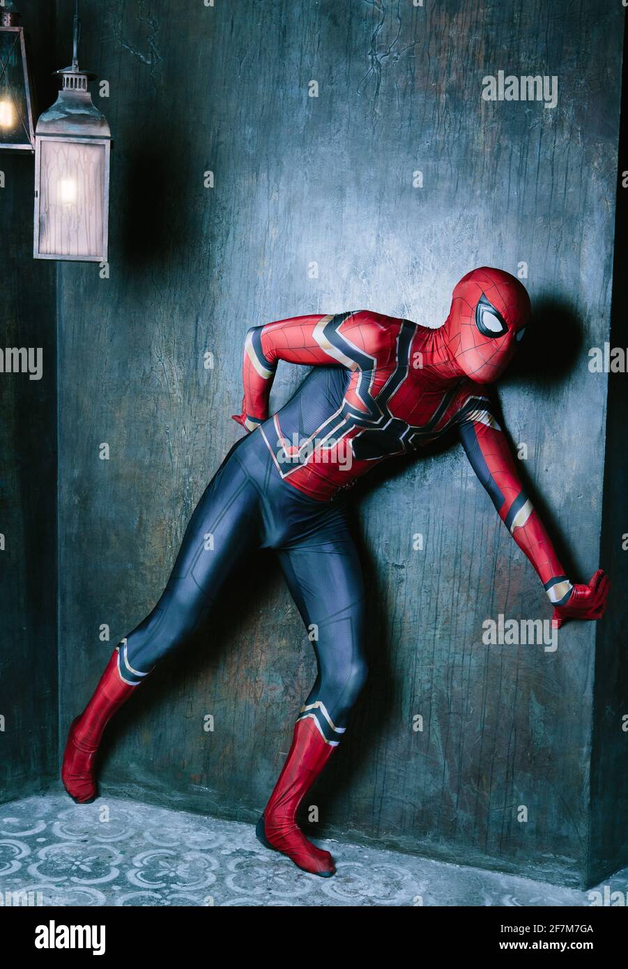 Schauspieler kleiden sich als Spiderman, der gegen eine alte Wand posiert  Das Studio Stockfotografie - Alamy