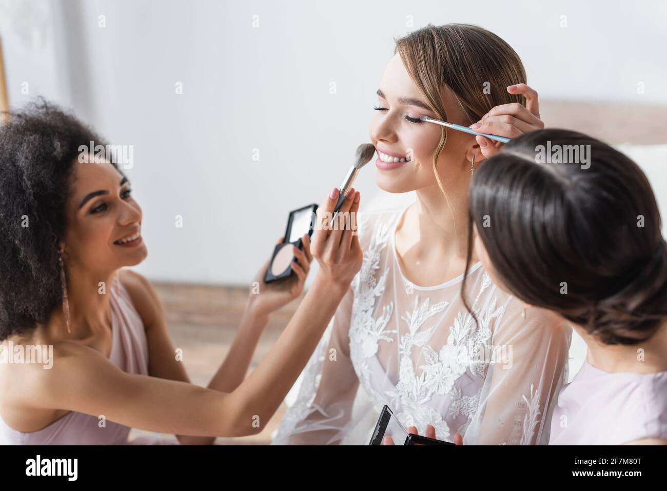 Interracial Frauen Make-up zu glücklich Braut im Schlafzimmer Stockfoto