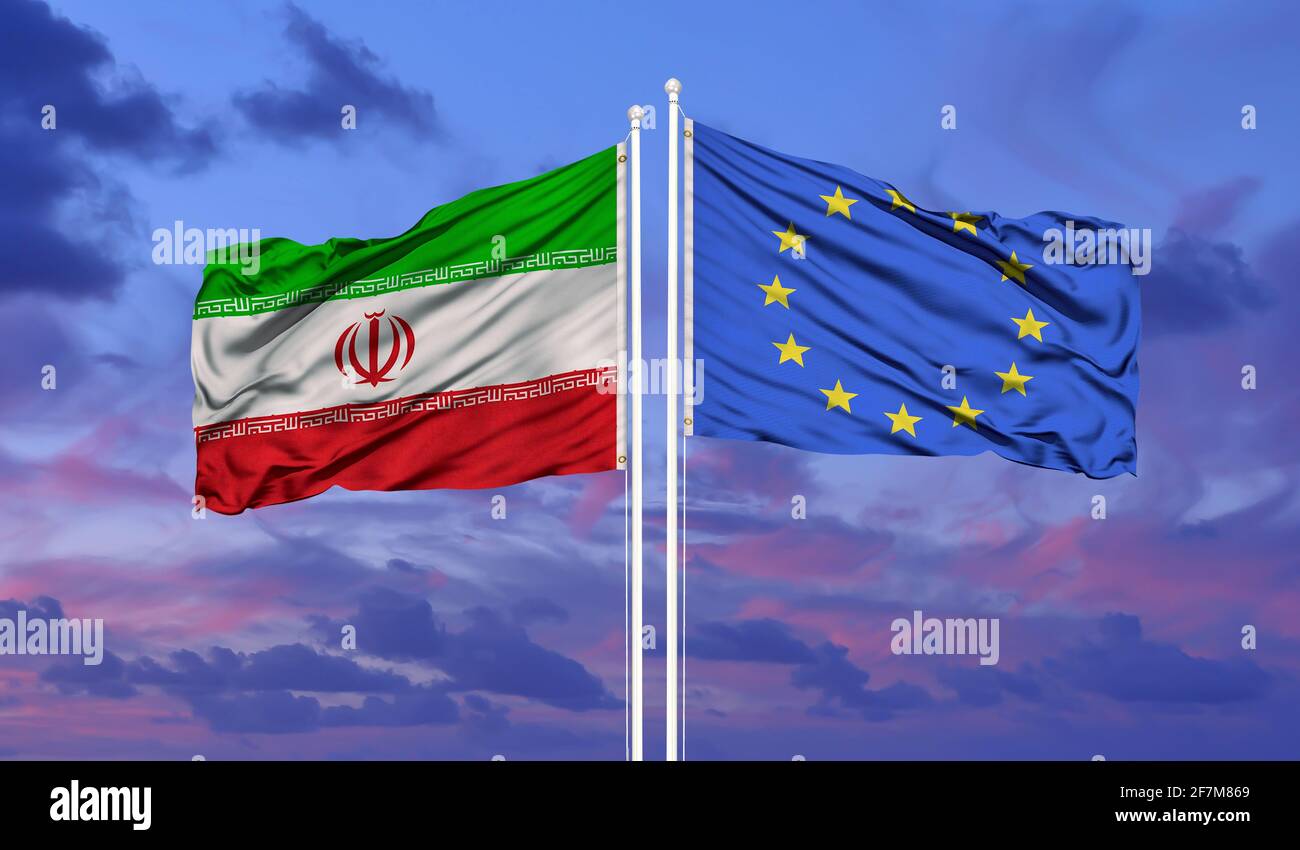 Iran und die Fahne der Europäischen Union winken im Wind gegen Weiße bewölkt blauer Himmel zusammen. Diplomatie Konzept, internationale Beziehungen. Stockfoto