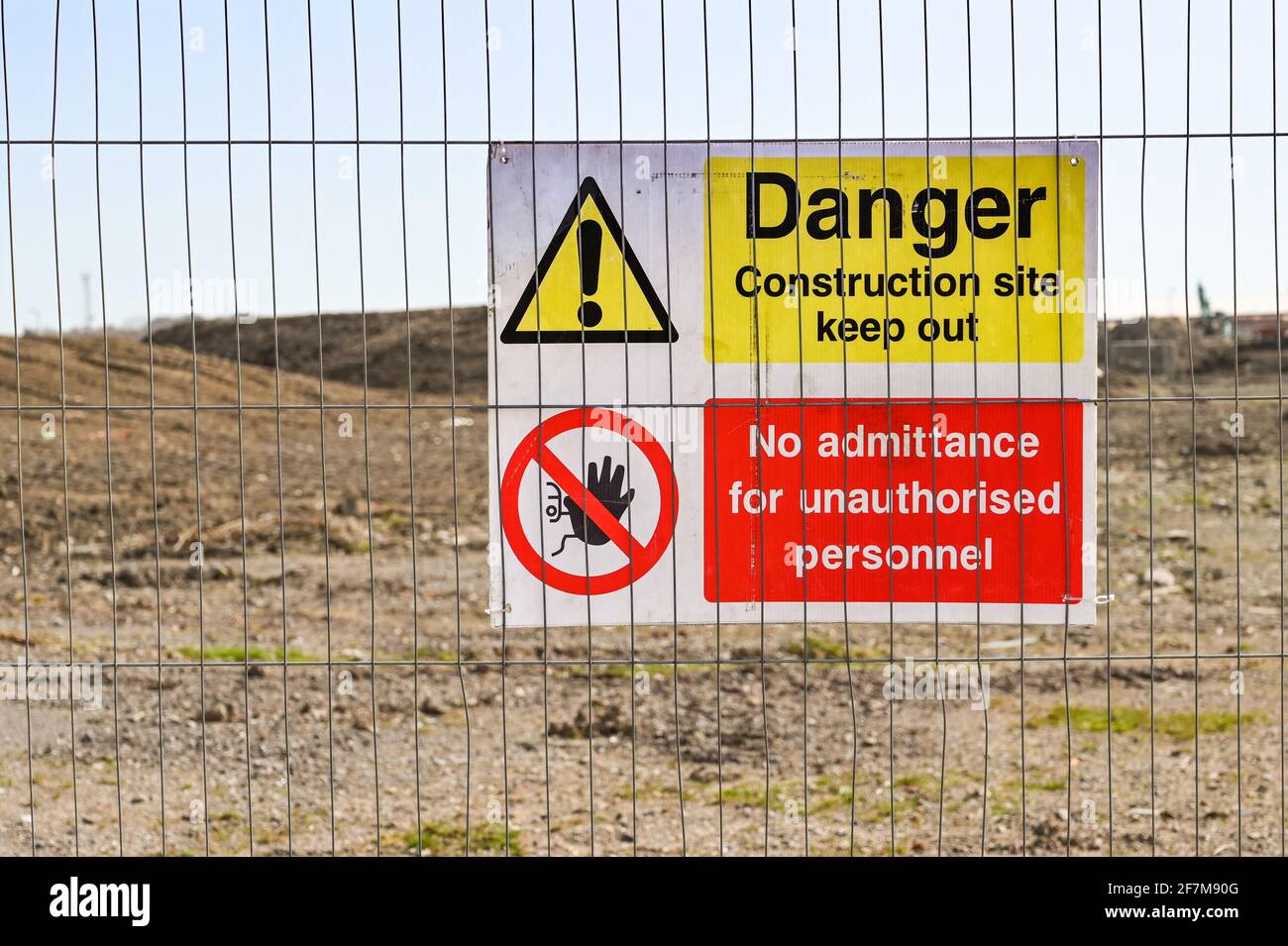 Gefahr Halten Sie ein Schild an einem Gitterzaun um eine Baustelle herum auf. Keine Personen. Stockfoto