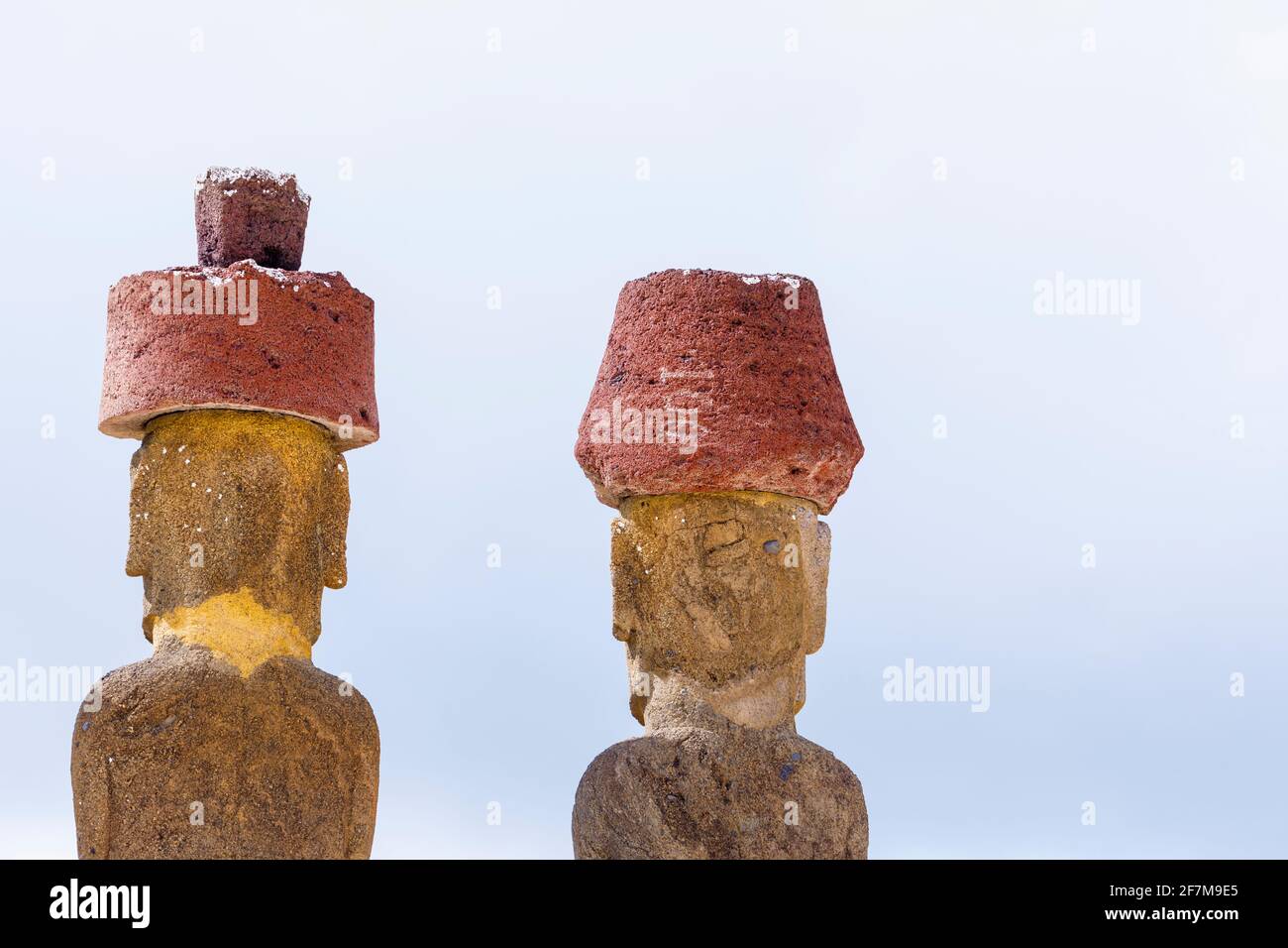 Rückansicht der Köpfe von restauriertem Moai mit roten Skorikürnchen (Pukao) auf Ahu Nao-Nao, Anakena Beach an der Nordküste der Osterinsel (Rapa Nui) Stockfoto