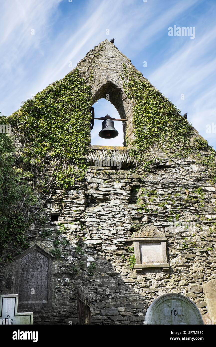 In den Ruinen einer alten mittelalterlichen Kirche in der Mitte des Friedhofs im Dorf Ardcath, Meath, Irland, hängt immer noch eine Glocke Stockfoto