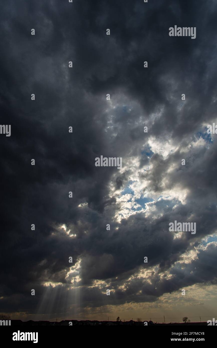 Sonnenstrahlen durch graue Wolken über Ankeny, Iowa. Stockfoto