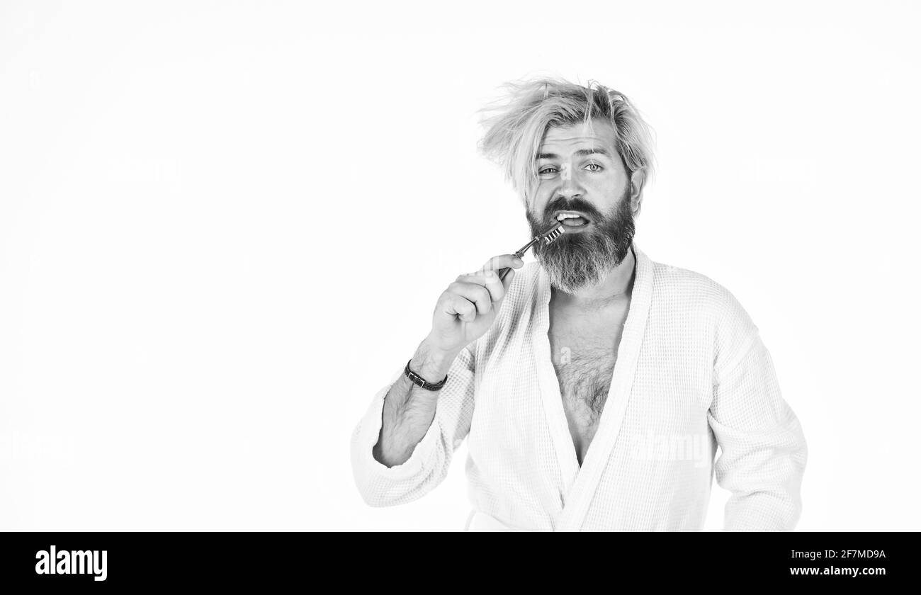 Morgendliche Routine. Mundhygiene. Mann im Bademantel hält die Zahnbürste. Persönliche Hygiene. Bärtige Hipster putzen Zähne. Frische und Sauberkeit. Behalten Stockfoto