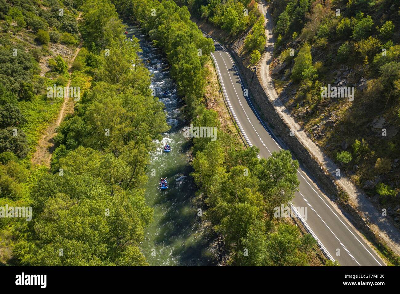 Luftblick auf den Fluss Noguera Pallaresa, eine Bergstraße und einige Boote, die beim Rafting abfahren (Pallars Sobirà, Pyrenäen, Katalonien, Spanien) Stockfoto