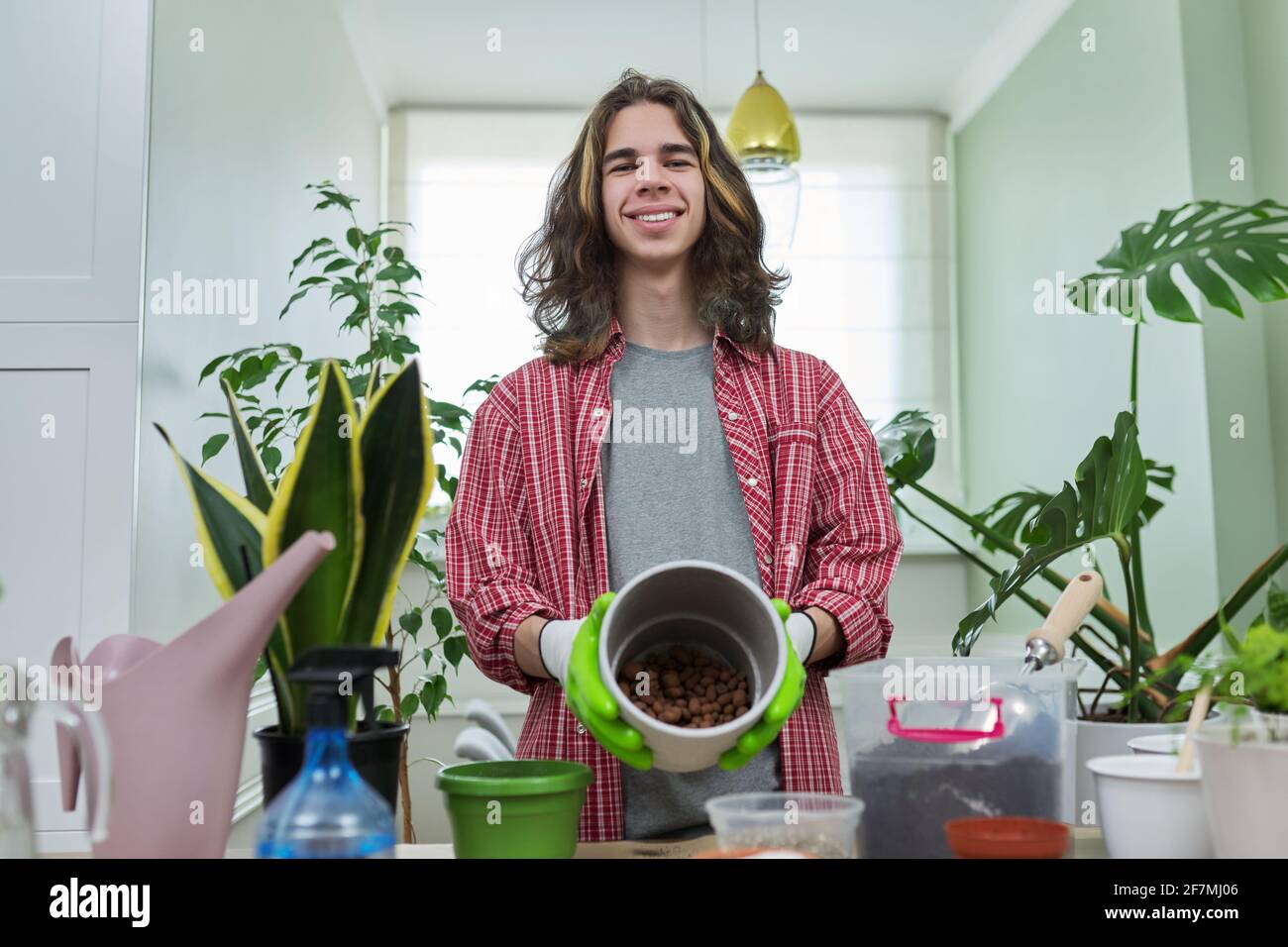 Grünes Öko Hobby des jungen Mannes, Teenager zeigt Pflanze, Erde, Topf Stockfoto