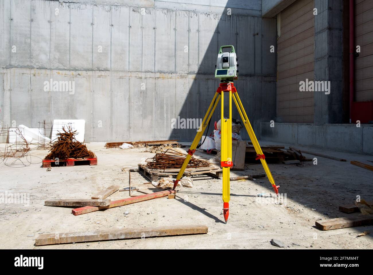 Gerät zur Geodäsie-Messung auf einer Baustelle gegen eine Hintergrund einer grauen Wand Stockfoto