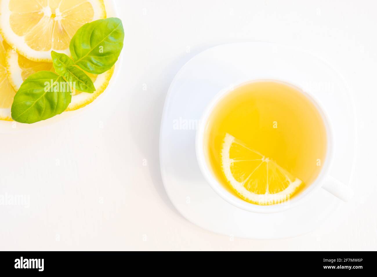 Tasse grüner Tee mit Zitrone, Basilikum und Minze schießen von oben isoliert auf weißem Hintergrund mit Platz für Text Stockfoto