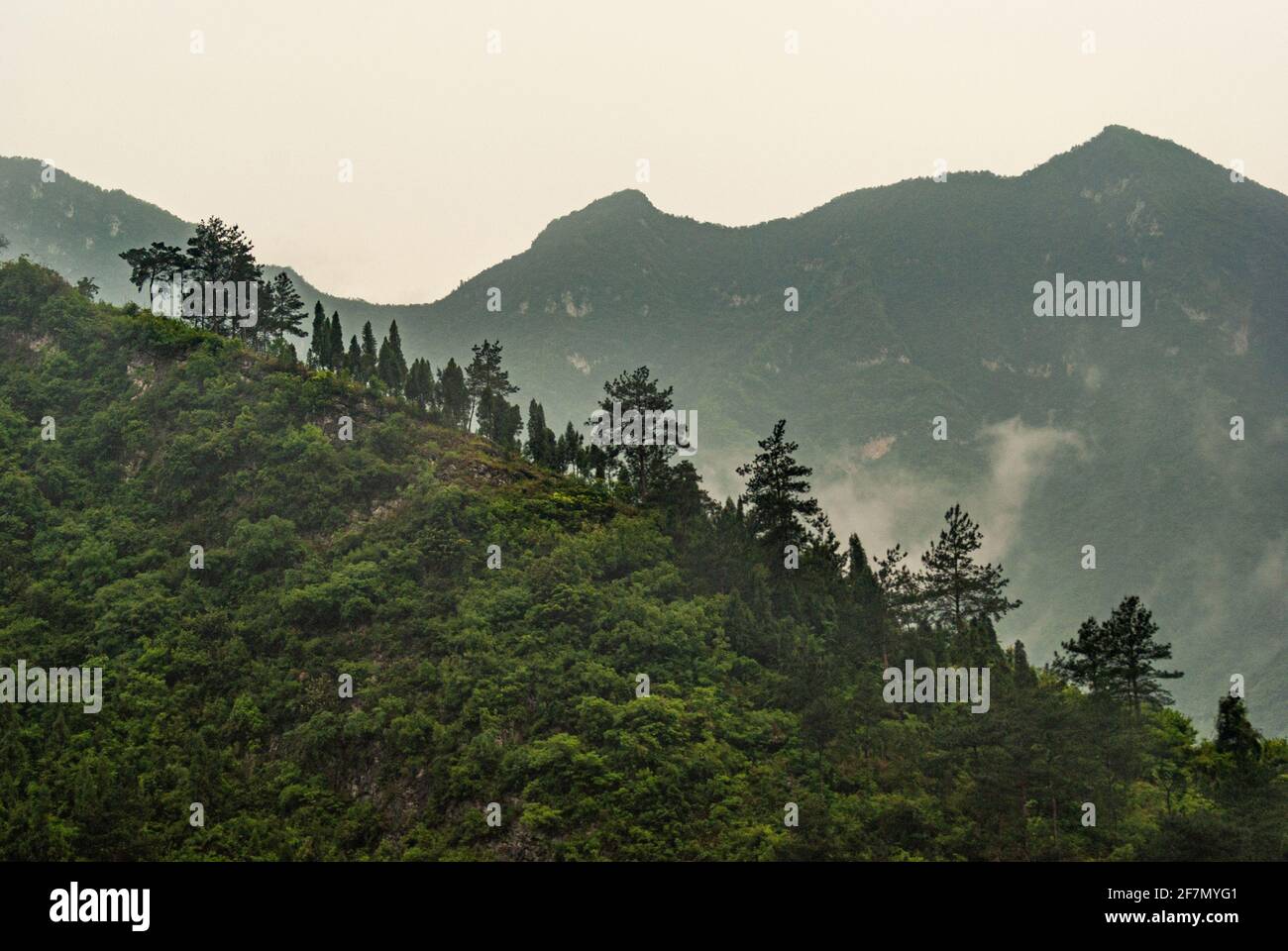 Drei-Schluchten-Staudamm, China - 6. Mai 2010: Nahaufnahme von Geen-Hügeln unter nebligen Morgenhimmel über dem Staudamm. Stockfoto