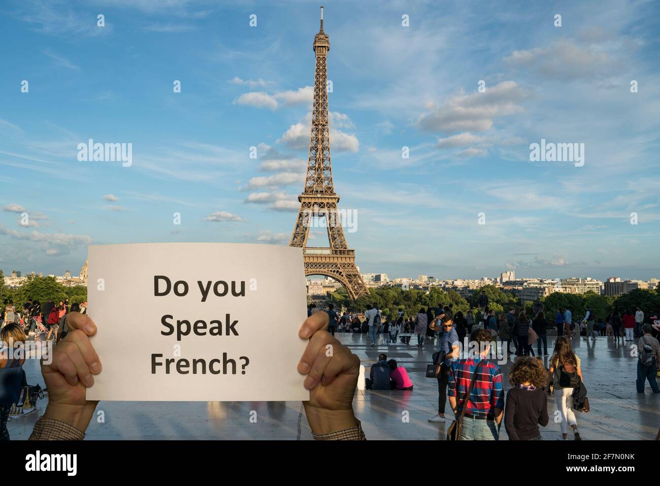 Ein Mann mit einem Zeichen in seinen Händen und der Eiffelturm im Hintergrund Stockfoto