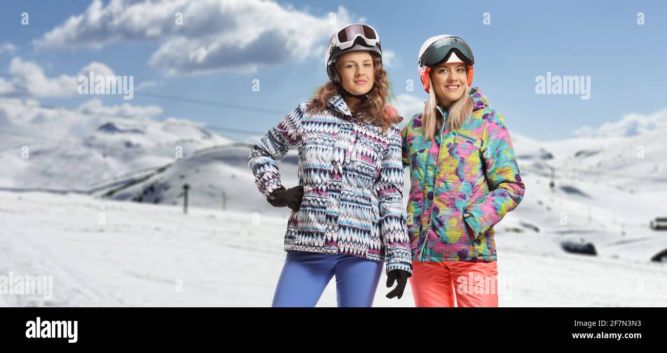 Junge Frauen in Winterskikleidung posieren auf einem verschneiten Berg Stockfoto