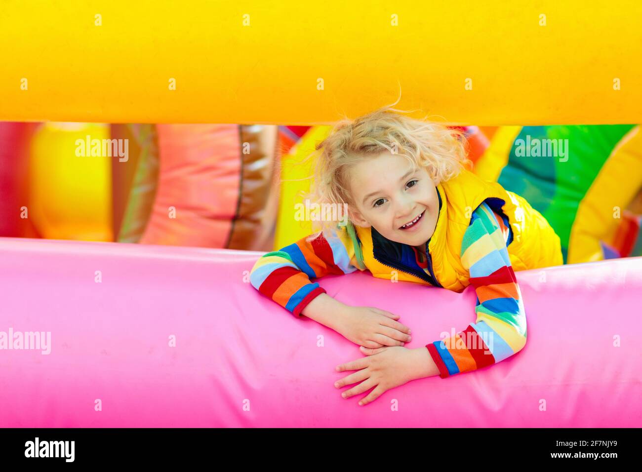 Kinder springen auf buntem Spielplatz-Trampolin. Kinder springen in aufblasbare Sprungburg auf Kindergarten Geburtstagsparty Aktivität und Spielzentrum Stockfoto
