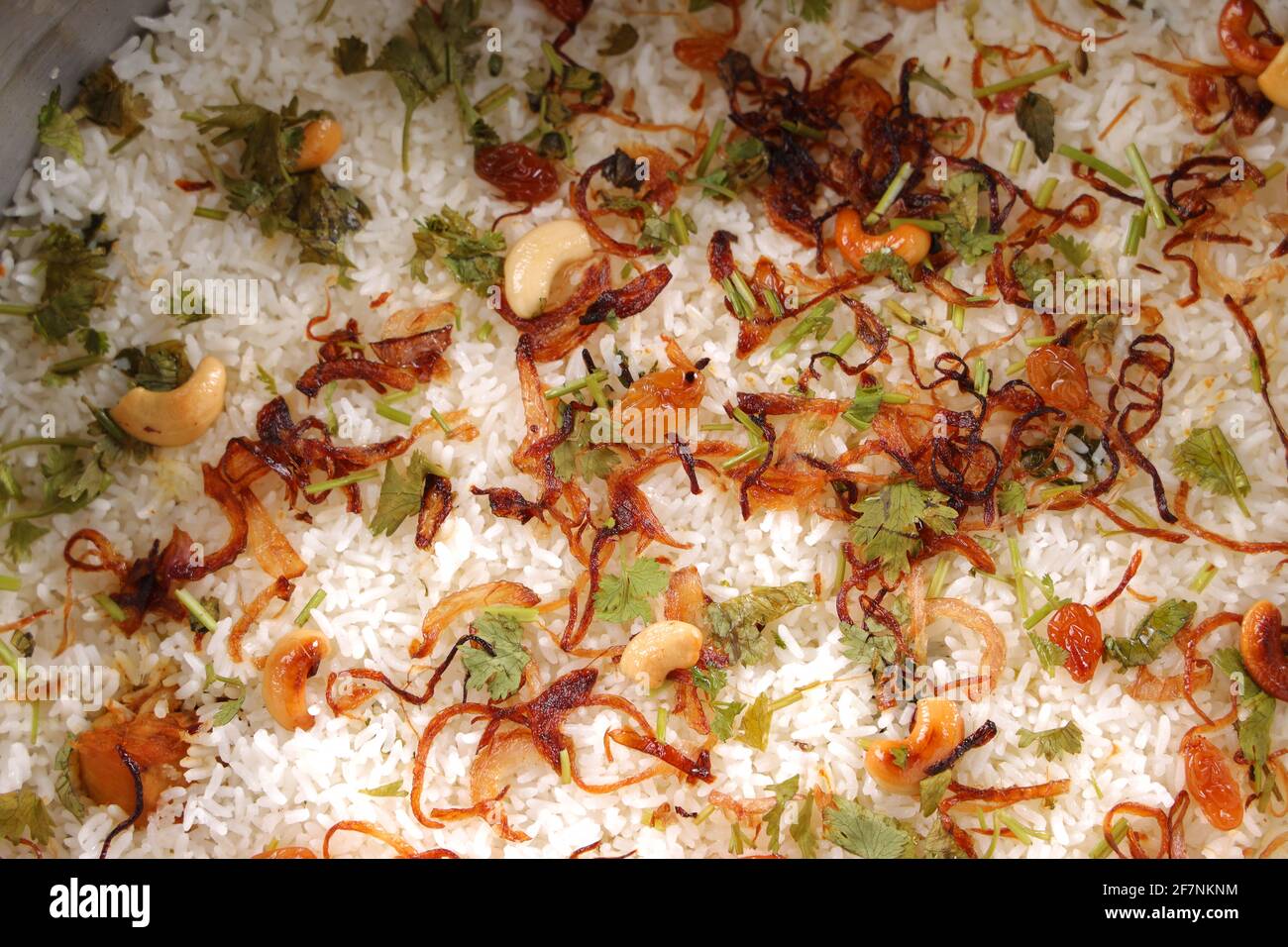 Dum Chicken biriyani, Nahaufnahme Bild von Kerala-Thalassery biriyani garniert mit gebratener Zwiebel, Cashewnuss, Rosinen und Korianderblatt, das angeordnet ist Stockfoto