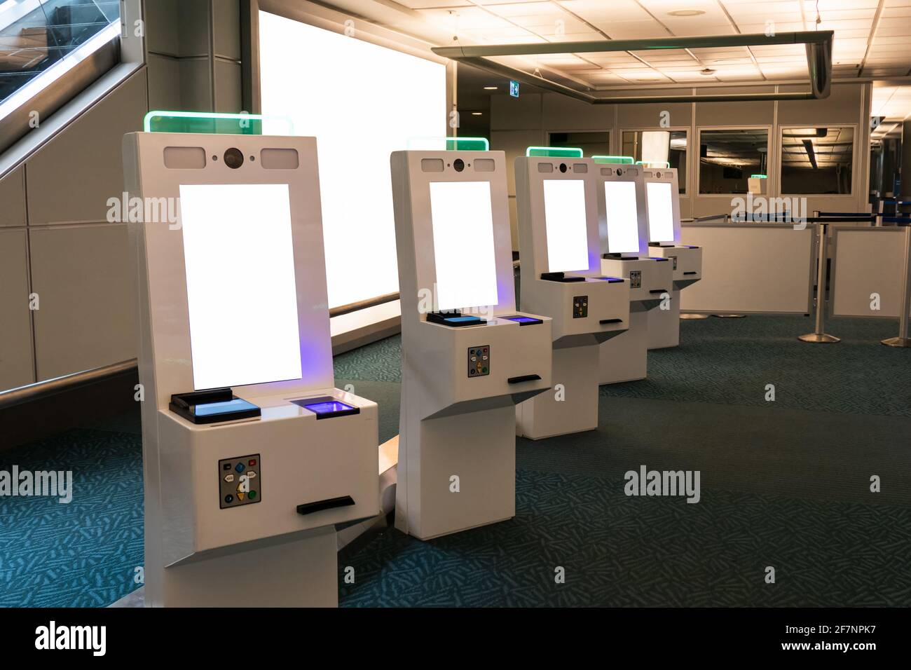 Reihe mit Selbstbedienungskartenspender mit Passscanner Touch Bildschirm in der Einwanderungszone am Flughafen Stockfoto