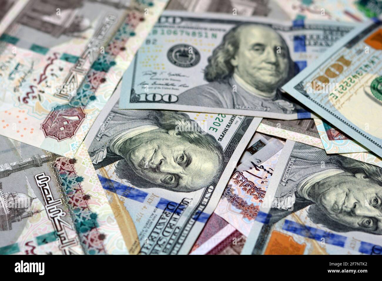 Ägyptische Landeswährung mit US-Dollar-Banknoten im Hintergrund. Geldscheine. Ägyptische Pfund-Banknoten und amerikanische Dollar-Rechnungen Hintergrund. Stockfoto