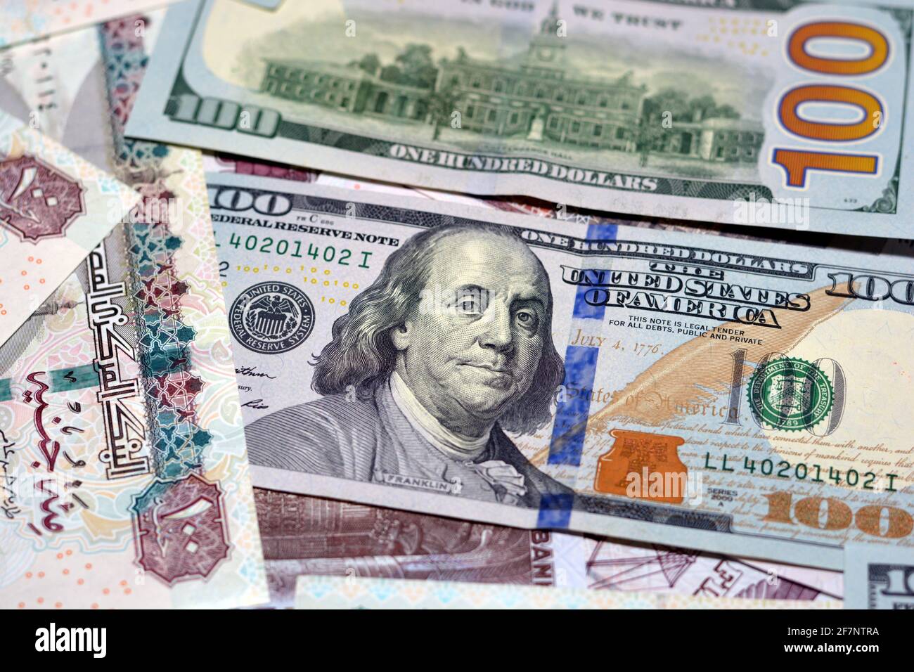 Ägyptische Landeswährung mit US-Dollar-Banknoten im Hintergrund. Geldscheine. Ägyptische Pfund-Banknoten und amerikanische Dollar-Rechnungen Hintergrund. Stockfoto