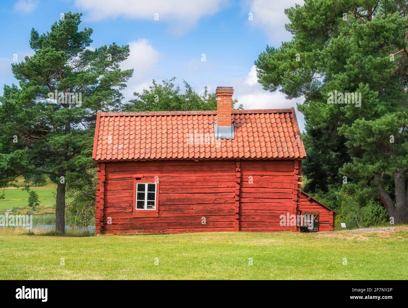 Gemütliches rotes Holzhaus mit hellen und sonnigen Sommertagen in Åland, Finnland Stockfoto