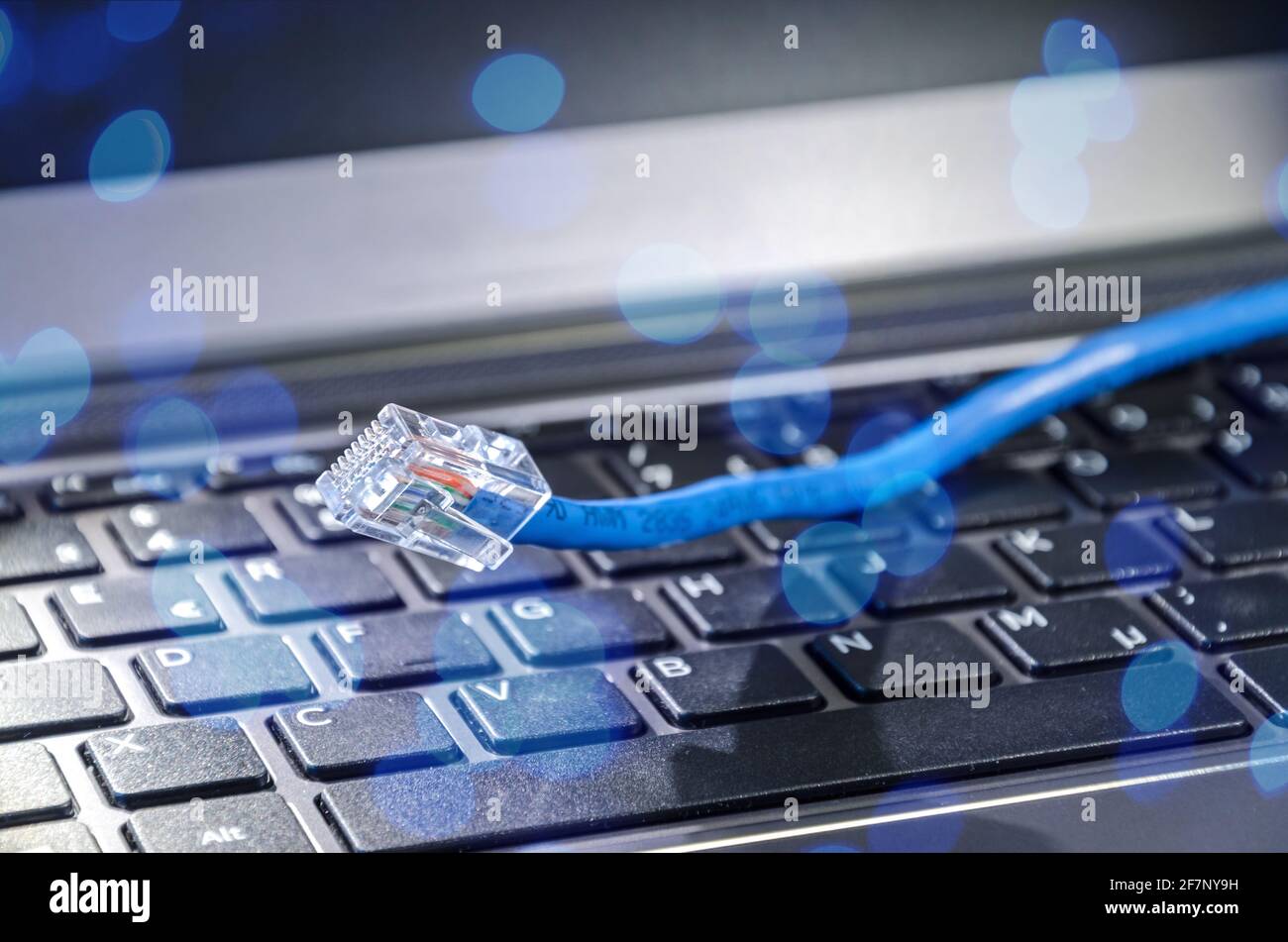 Internet-LAN-Kabel auf einer Computertastatur, die Cyberspace und symbolisiert Konnektivität Stockfoto