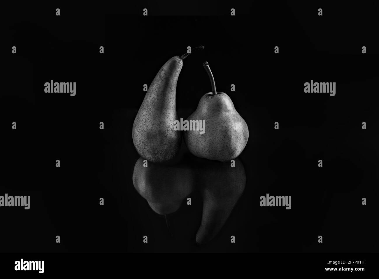 Zwei Birnen verschiedener Sorten auf schwarzem matten Hintergrund. Das Konzept von Toleranz und Körperpositiver. Stockfoto