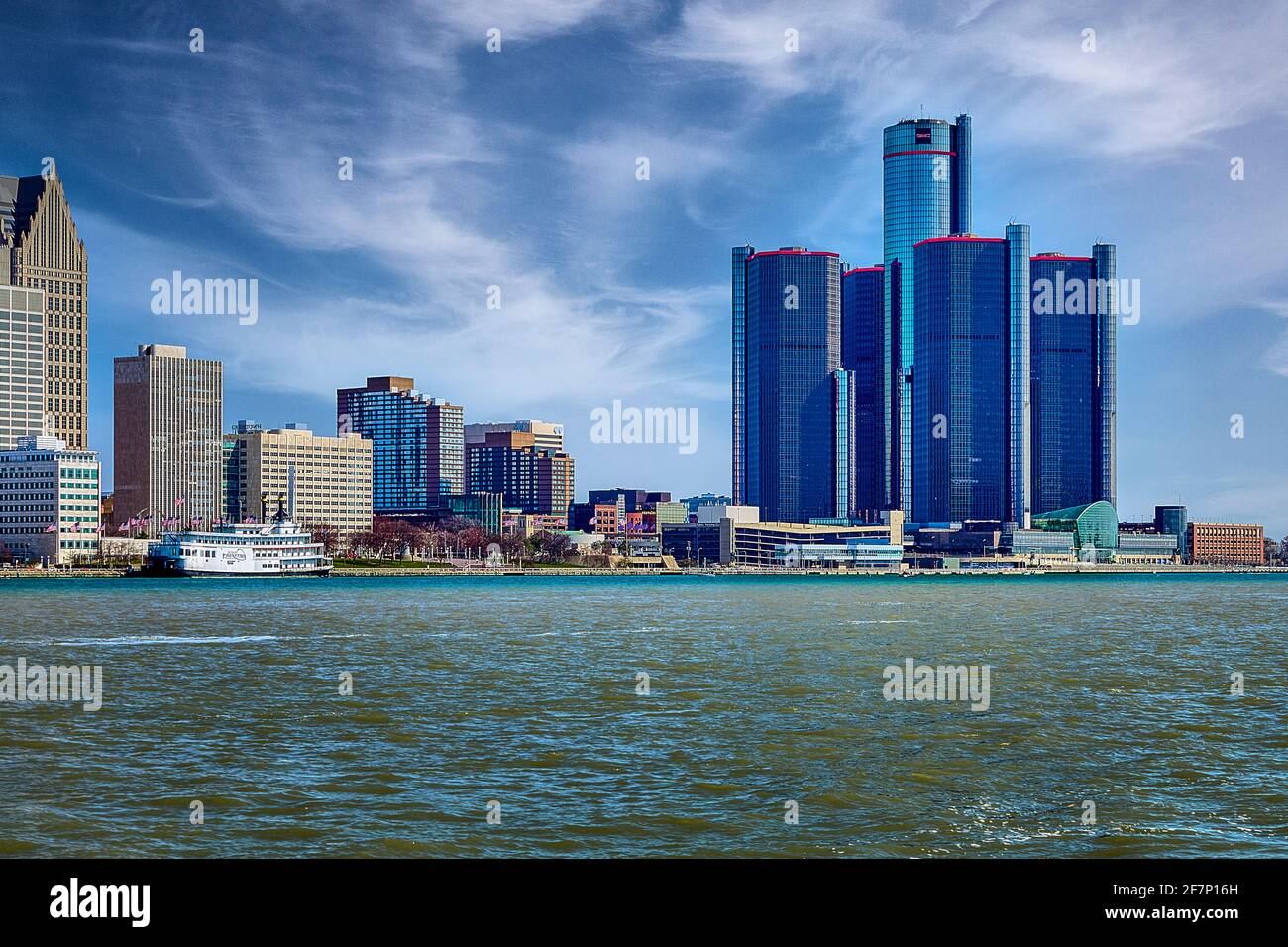 Wolkenkratzer in der Nähe des Flusses bei Tag. Moderne Hochhäuser am Ufer des Flusses gegen den wolkigen blauen Himmel in Detroit, USA Stockfoto