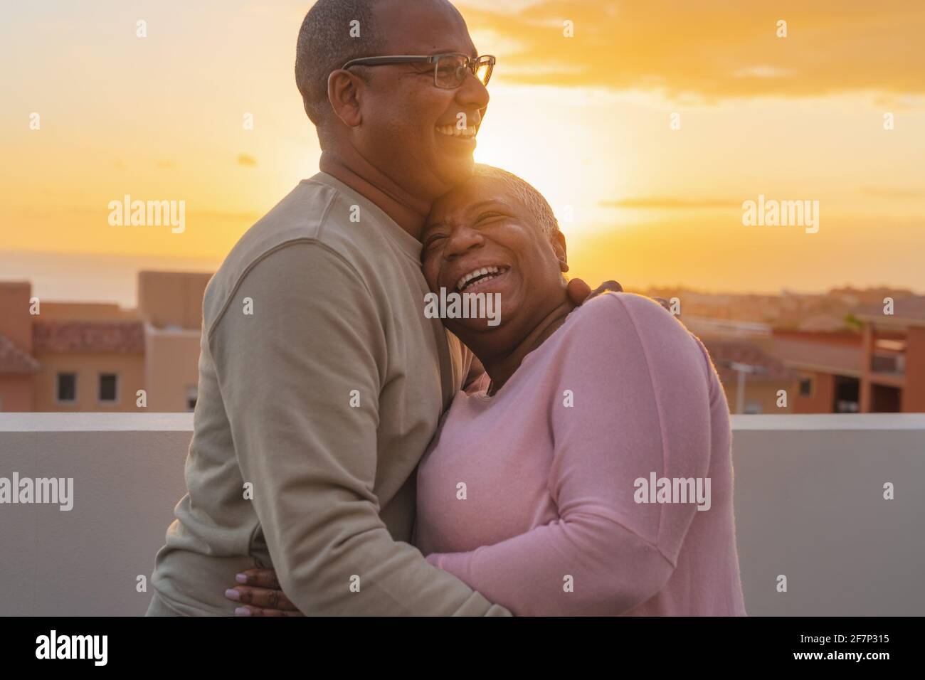 Ein glückliches lateinisches Seniorenpaar, das einen romantischen Moment auf dem Dach hatte Während der Sonnenuntergangszeit - ältere Menschen lieben Konzept Stockfoto