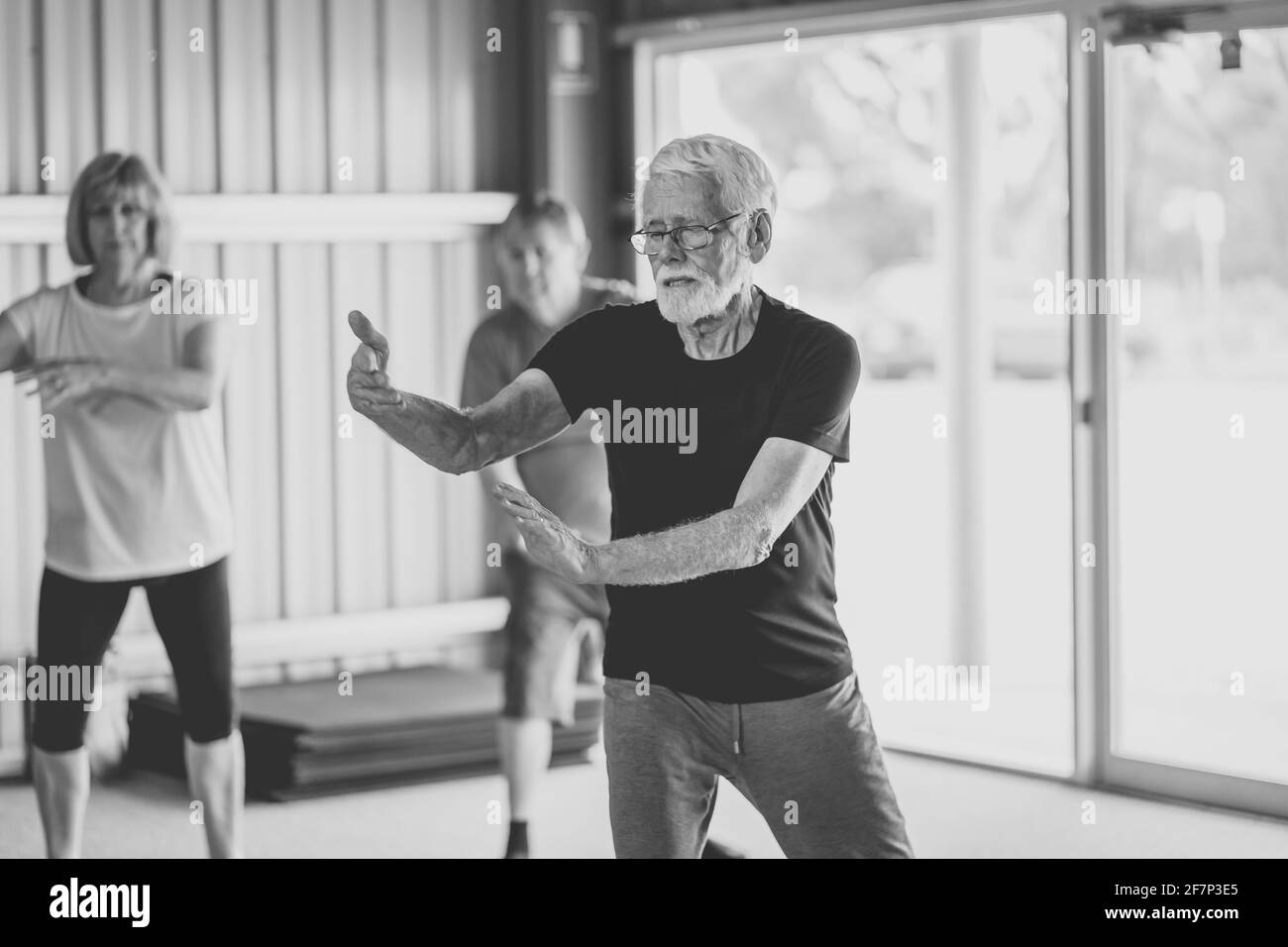 Gruppe von Senioren in Tai Chi Klasse Ausübung in einem aktiven Ruhestand Lebensstil. Psychische und körperliche Gesundheit Vorteile von Bewegung und Fitness bei älteren Menschen Stockfoto