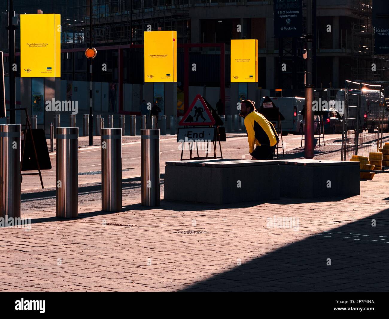 Straßenarbeiten in EINER Londoner Straße mit Yellow Sign Post-Werbetafeln und EINEM Mann mit EINER Yellow Jacket. Stockfoto