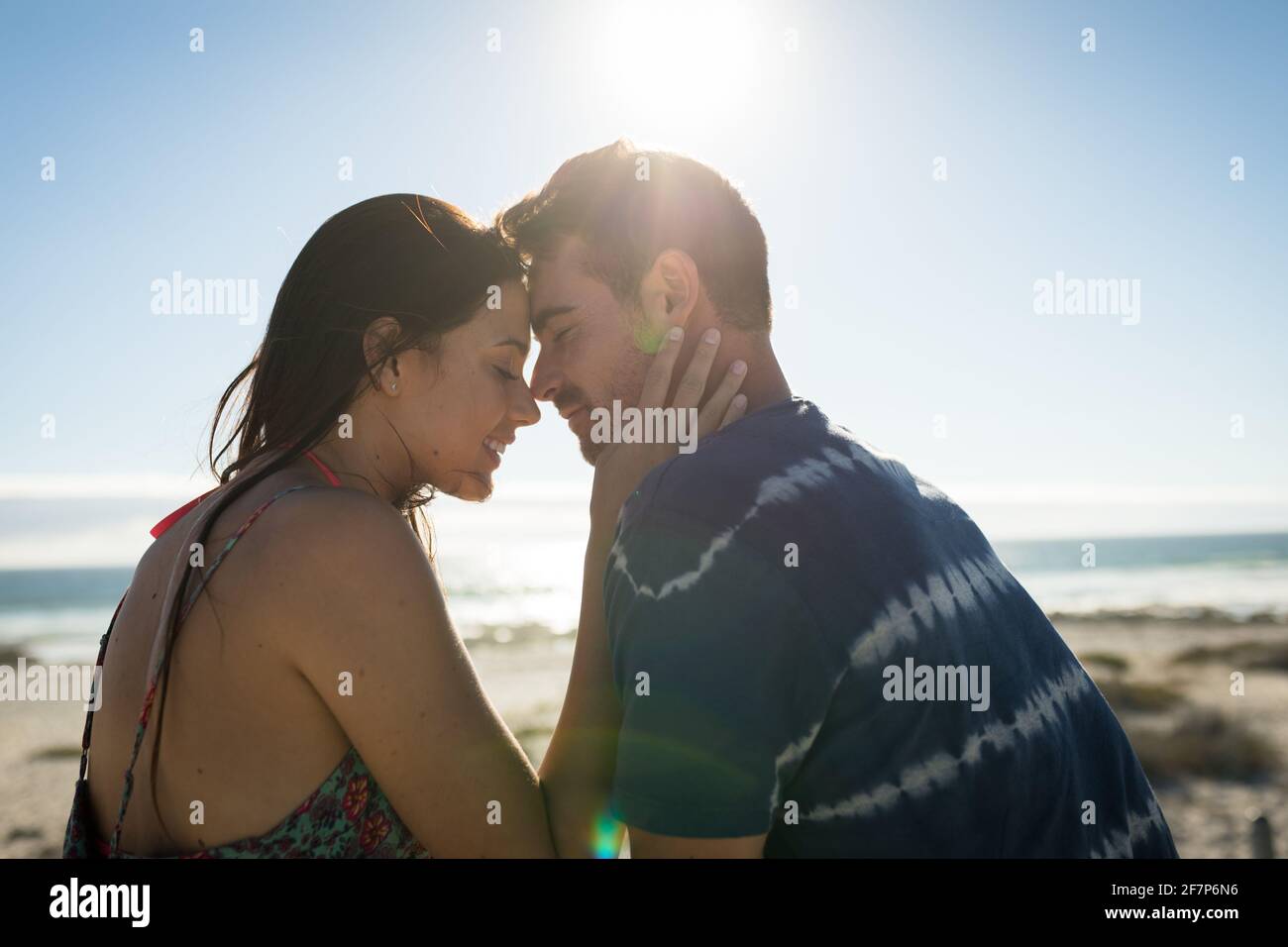 Glückliches kaukasisches Paar am Strand, das die Stirn berührte Stockfoto