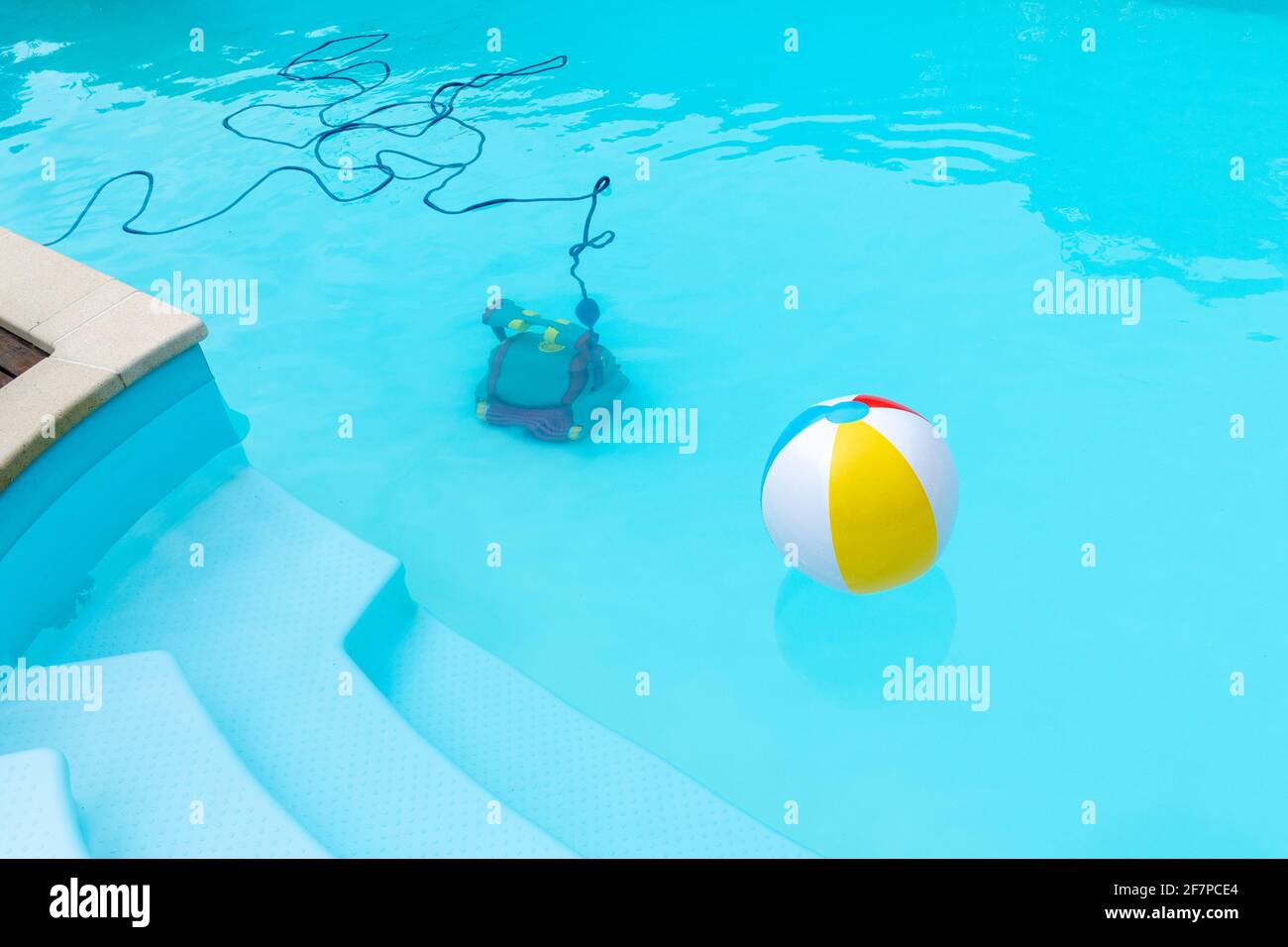 Unterwasser-Roboter Reinigung eines Schwimmbades und einer aufblasbaren Kugel schwimmend . Konzept des Wartungspools. Speicherplatz kopieren Stockfoto