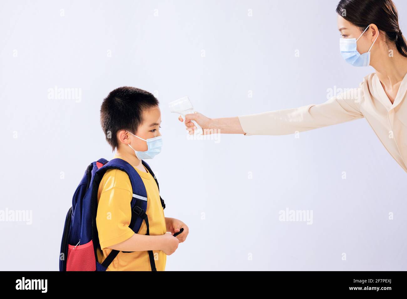 Der kleine Junge nahm seine Temperatur vor der Schule an seinem Mama Stockfoto