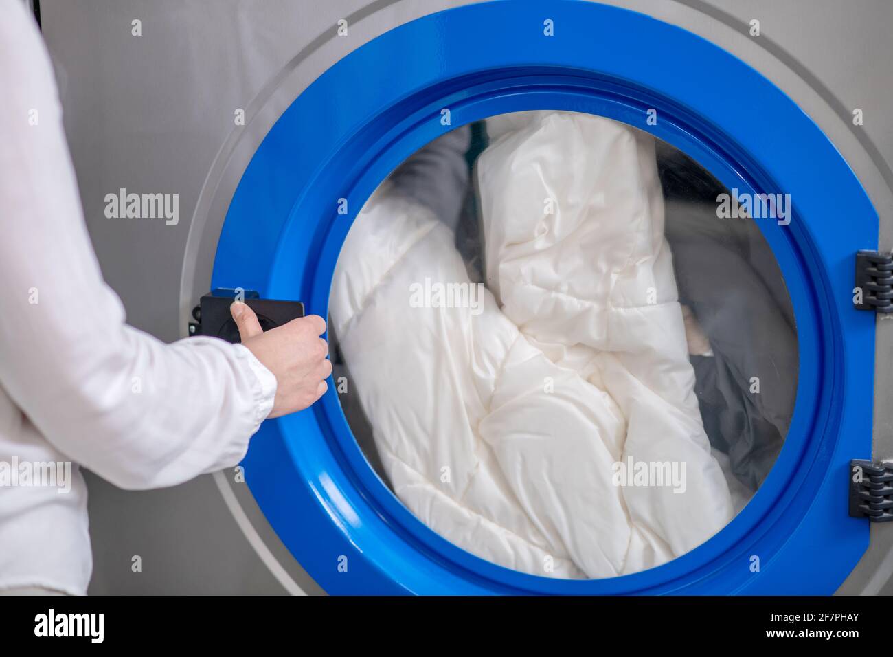 Frauen öffnen die Tür der Waschmaschine mit der Hand Stockfoto