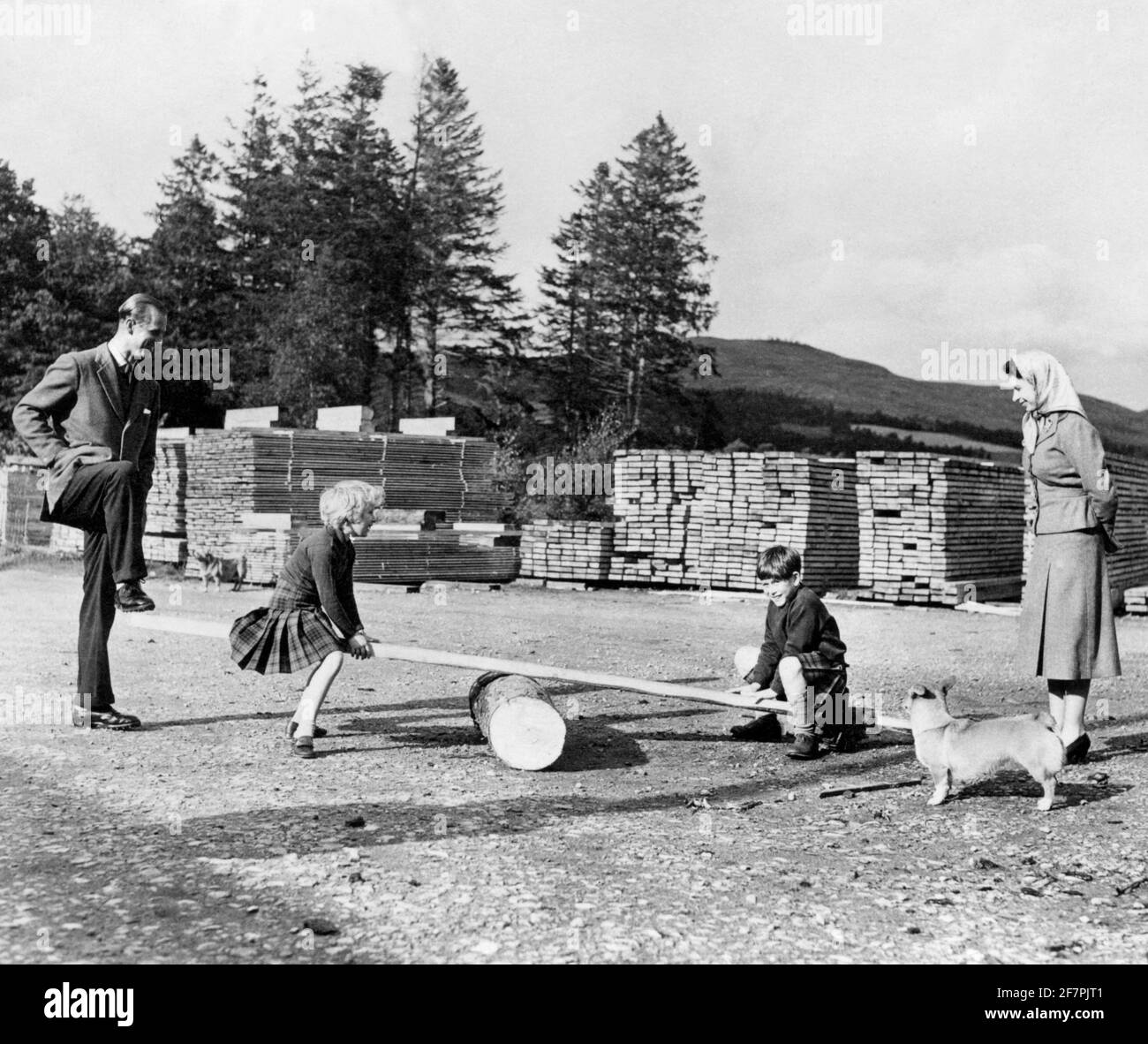 Datei-Foto vom 15/09/57 des Prinzen von Wales mit seiner Schwester Prinzessin Anne, die von ihren Eltern, Königin Elizabeth II. Und dem Herzog von Edinburgh, genau beobachtet wurde und mit Hilfe ihres Vaters auf dem Balmoral Estate auf einer Säge aus einem Baumstamm und einem Holzbrett spielte, In den Highlands, einem der beliebtesten Orte der königlichen Familie, hielt viele Erinnerungen für den Herzog von Edinburgh. Die Königin war einst angeblich nie glücklicher als damals bei Balmoral, auch Philip liebte das Leben im Freien, das gleichbedeutend mit ihrer jährlichen Pause war, die von Ende Juli bis Oktober reichte. Ausgabedatum: Freitag AP Stockfoto