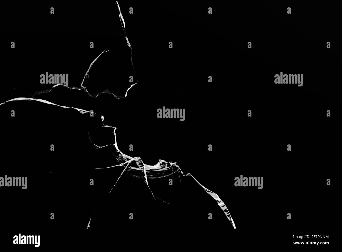 Risse im Glas, Löcher von Kugeln auf schwarzem Hintergrund. Stockfoto