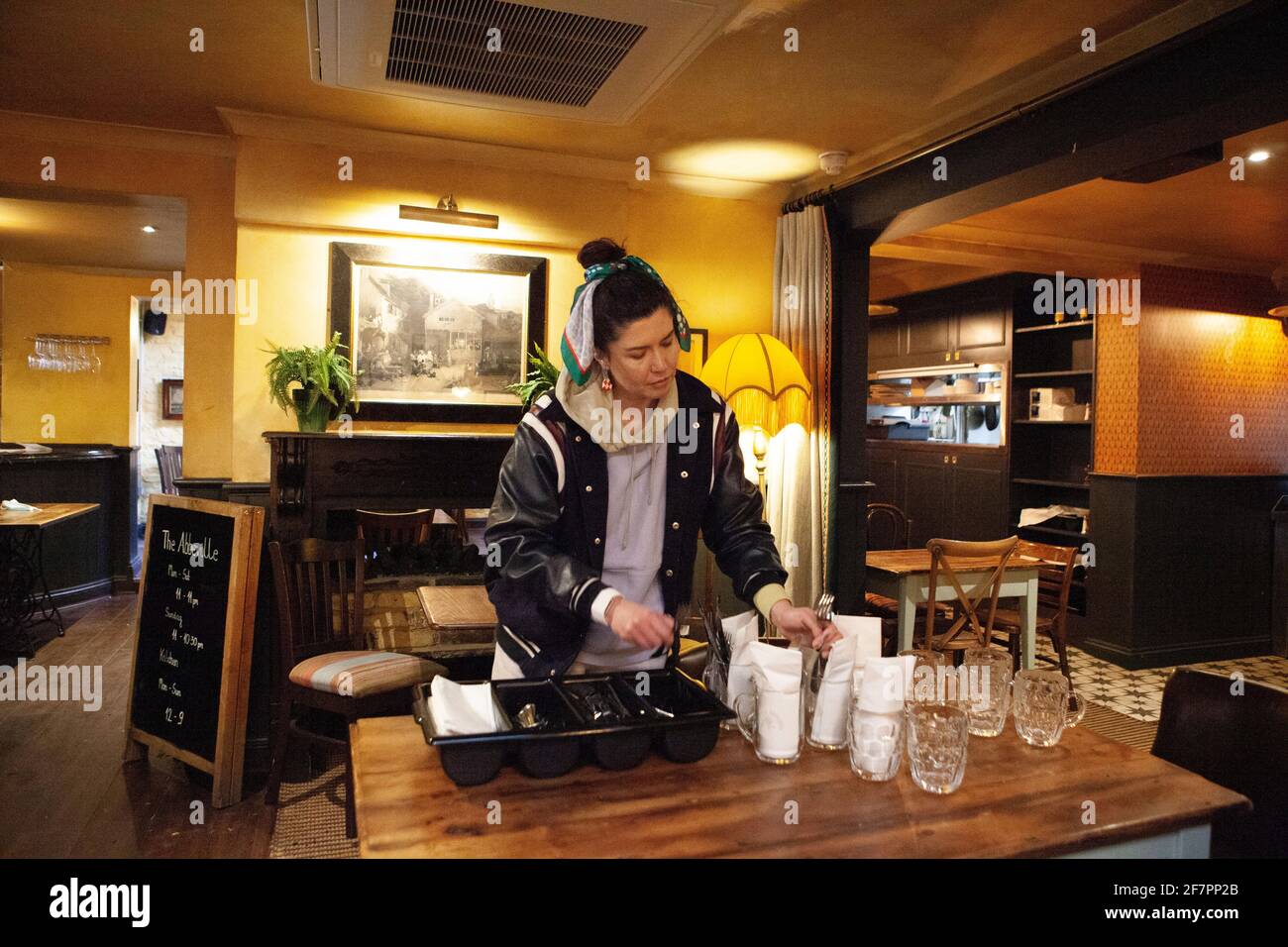 London, Großbritannien, 9. April 2021: Im Abbeville Pub in Clapham poliert Manager Armanda Besteck, um sich auf die Wiedereröffnung ab dem 12. April vorzubereiten. Manager Armanda poliert Besteck. Auf der Außenterrasse und auf den Tischen auf dem Bürgersteig werden den Gästen Getränke und Speisen serviert. Anna Watson/Alamy Live News Stockfoto