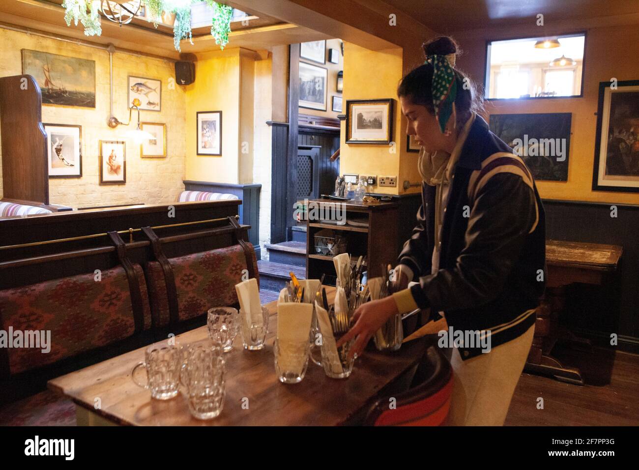 London, Großbritannien, 9. April 2021: Im Abbeville Pub in Clapham poliert Manager Armanda Besteck, um sich auf die Wiedereröffnung ab dem 12. April vorzubereiten. Manager Armanda poliert Besteck. Auf der Außenterrasse und auf den Tischen auf dem Bürgersteig werden den Gästen Getränke und Speisen serviert. Anna Watson/Alamy Live News Stockfoto