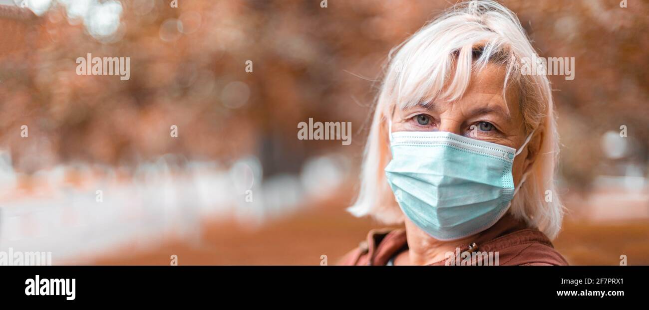 Coronavirus, COVID-19 Pandemiekonzept. Blonde Frau trägt Gesichtsmaske Schutz für Krankheit Virus SARS-CoV-2 an der Straße der Stadt Stockfoto