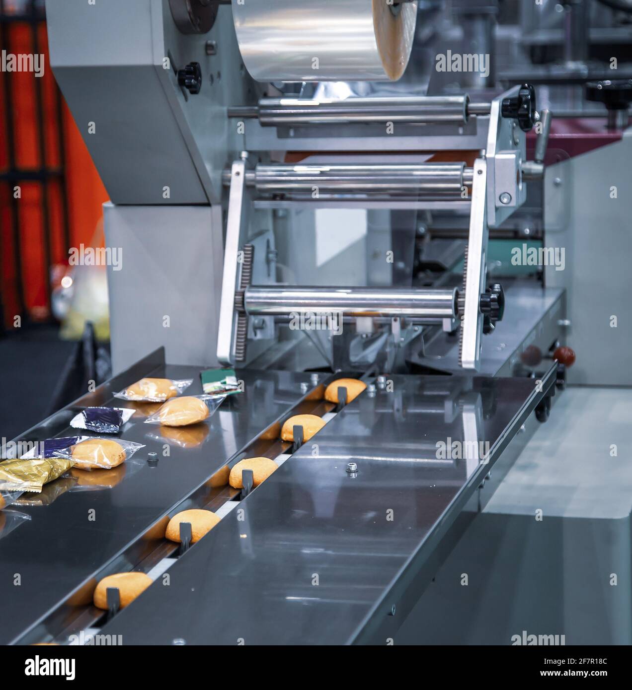 Kuchen auf Kunststofffolie Durchlaufverpackungsmaschine in Bäckerei Produktionslinie. Lebensmittelindustrie Stockfoto