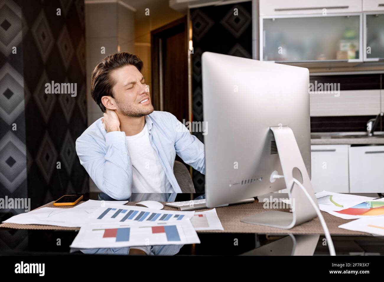 Attraktiver männlicher Mitarbeiter führt eine Videokonferenz durch, diskutiert mit Kollegen ein Projekt und lächelt. Ein gutaussehender Geschäftsmann in stilvollem Anzug verwendet Stockfoto