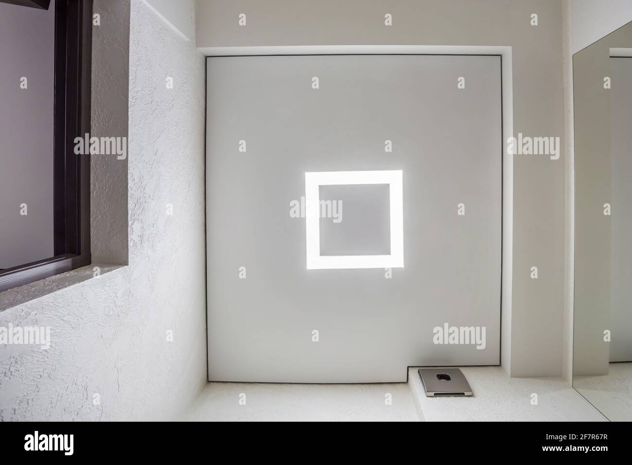 Abgehängte Decke mit Halogenstrahlern und Trockenmauerkonstruktion im leeren Raum in Wohnung oder Haus. Stretchdecke weiß und komplex. Stockfoto