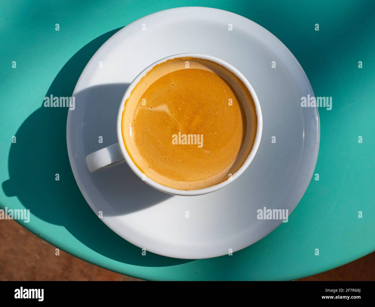 Nahaufnahme einer Tasse Kaffee mit Milch auf einem Grüner Tisch Stockfoto