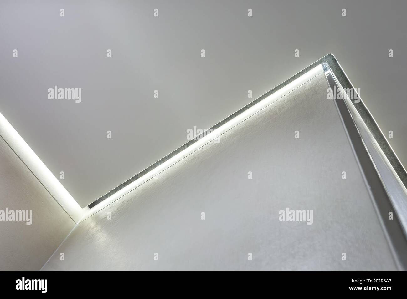 Abgehängte Decke mit Halogenstrahlern und Trockenmauerkonstruktion im leeren Raum in Wohnung oder Haus. Stretchdecke weiß und komplex. Stockfoto