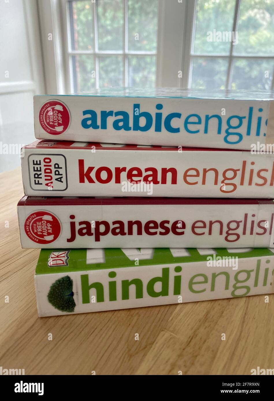 Ein Stapel zweisprachiger Phrasenbücher und Wörterbücher - Arabisch, Koreanisch, Japanisch und Hindi - aus der Bibliothek ausgeliehen. Stockfoto