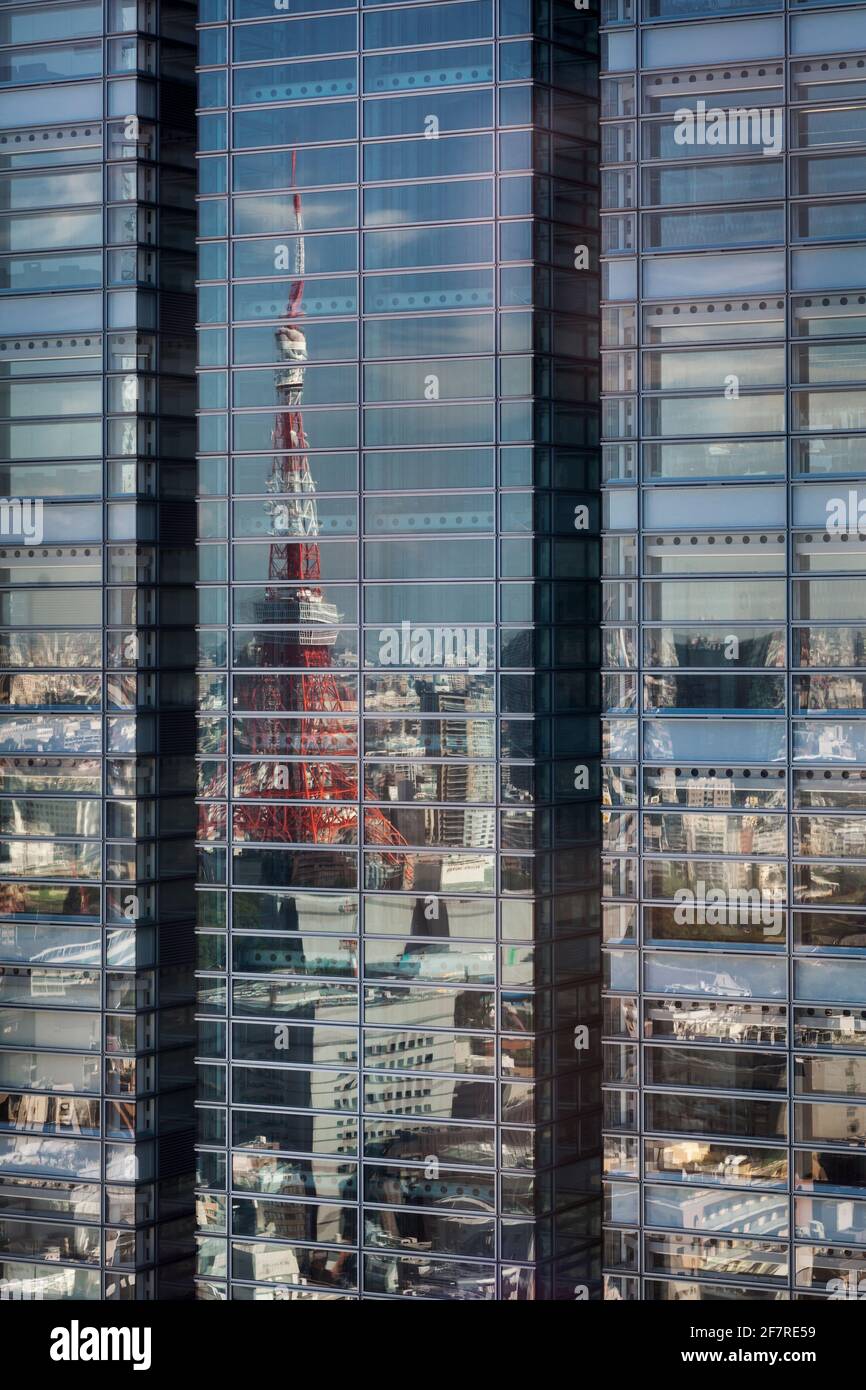 Vertikale Frontalansicht der verzerrten, Tokyo Tower Reflection auf einem gläsernen Wolkenkratzer, Minato City, Higashi-Shinbashi, Tokio, Japan Stockfoto
