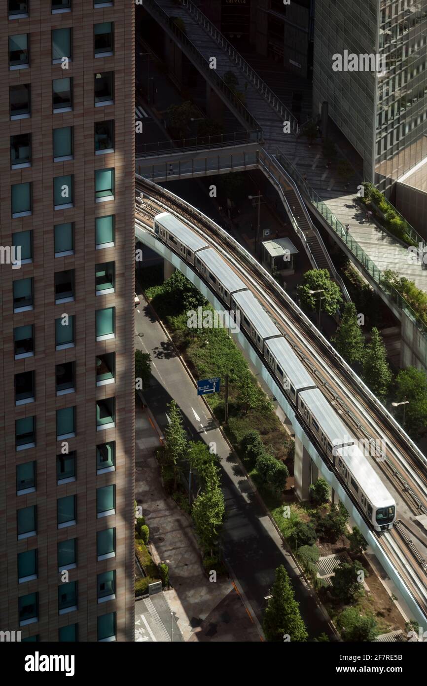 Vertikale Hochwinkelansicht des New Transit Yurikamome, der zwischen einigen der Wolkenkratzer von Minato City, Higashi-Shinbashi, Tokio, Japan, fährt Stockfoto