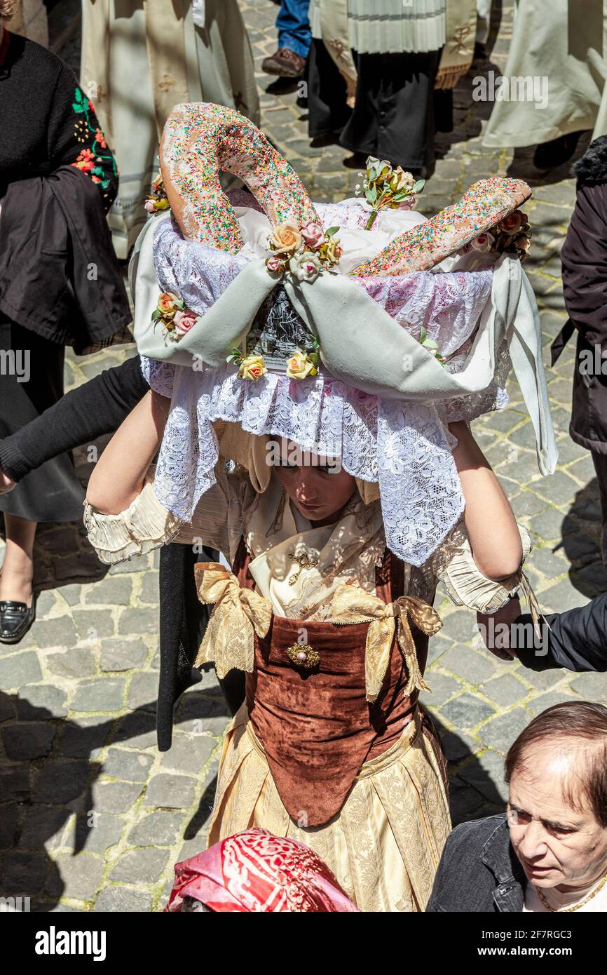 Mädchen in der traditionellen Tracht des Festivals trägt einen Korb mit Andachtsbrot auf ihrem Kopf. Fest von San Domenico. Cocullo, Abruzzen Stockfoto