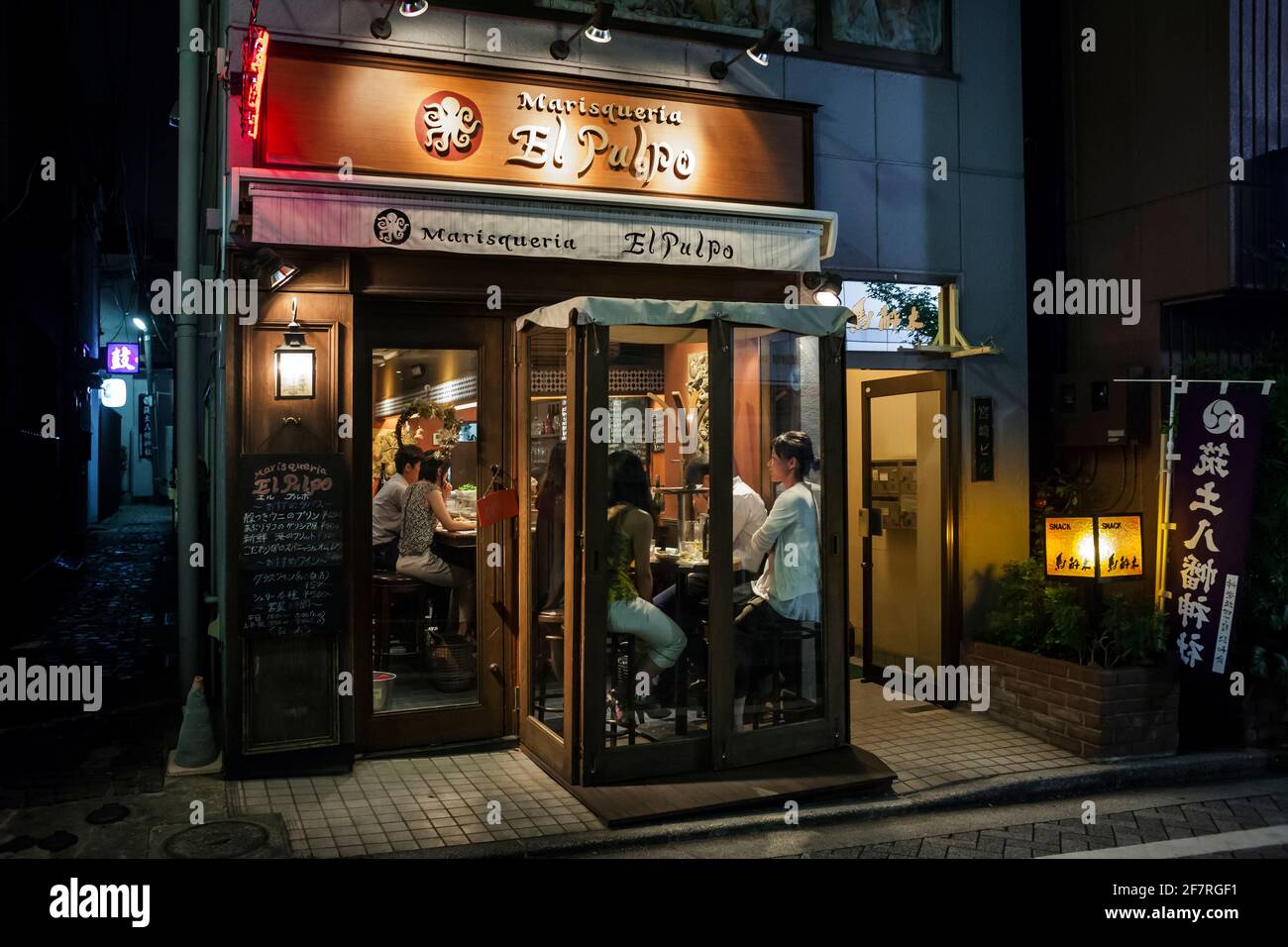 Horizontale Außenansicht eines gemütlichen und beliebten spanischen Restaurants voller Kunden in Kagurazaka, Tokio, Japan Stockfoto