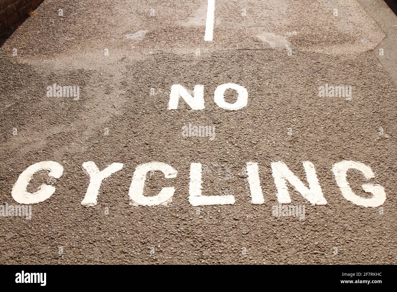 „No Cycling“ in Weiß auf asphaltierten Wegen gemalt. Stockfoto