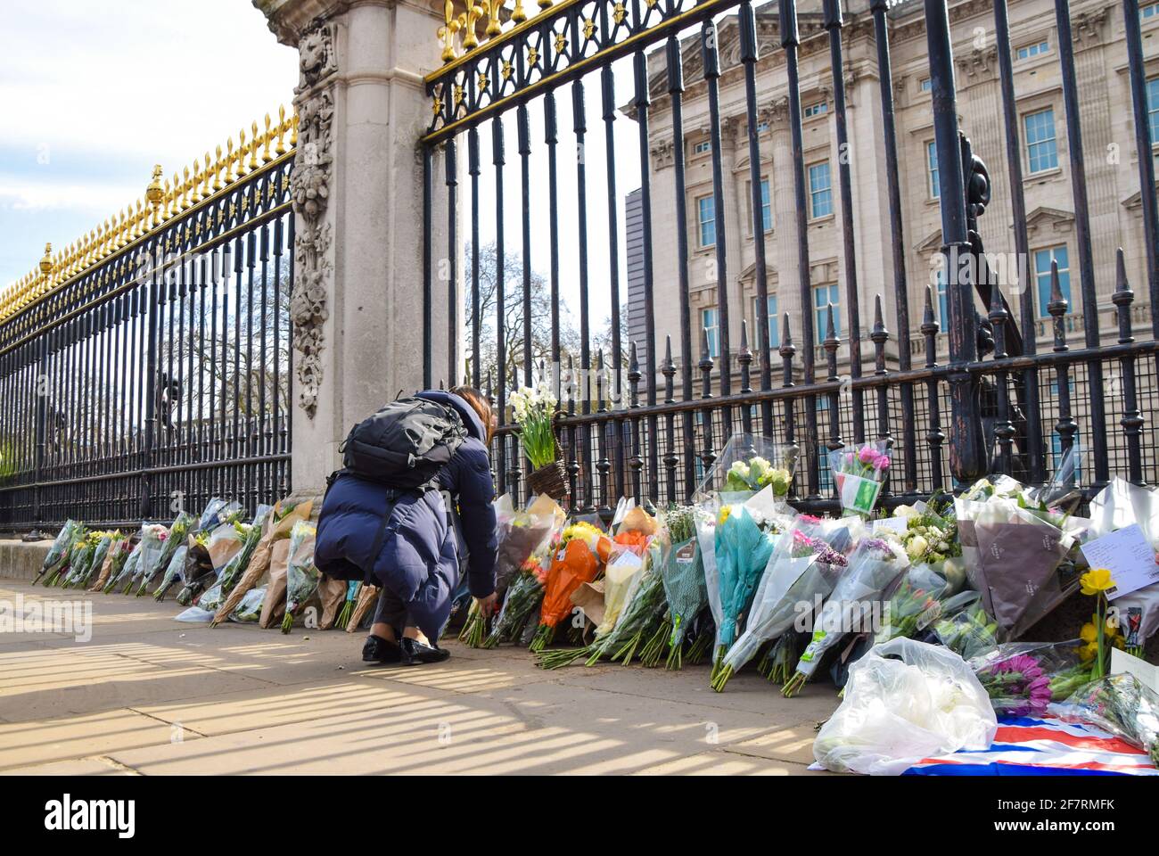 London, Großbritannien. April 2021. Eine Frau legt Blumen zu Ehren von Prinz Philip vor dem Buckingham Palace. Der Herzog von Edinburgh starb heute im Alter von 99 Jahren. Kredit: Vuk Valcic/Alamy Live Nachrichten Stockfoto