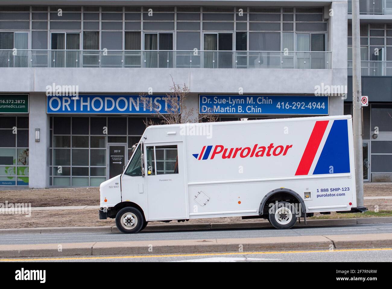 Ein Purolator-LKW, der Pakete in einem Gebäude in der Stadt Toronto, Kanada, liefert Stockfoto